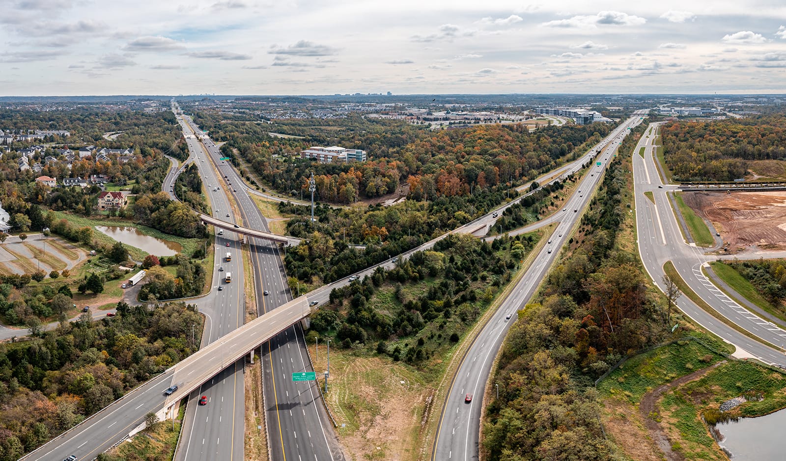 aerial image of overlapping highways surrounded by trees and suburban neighborhoods