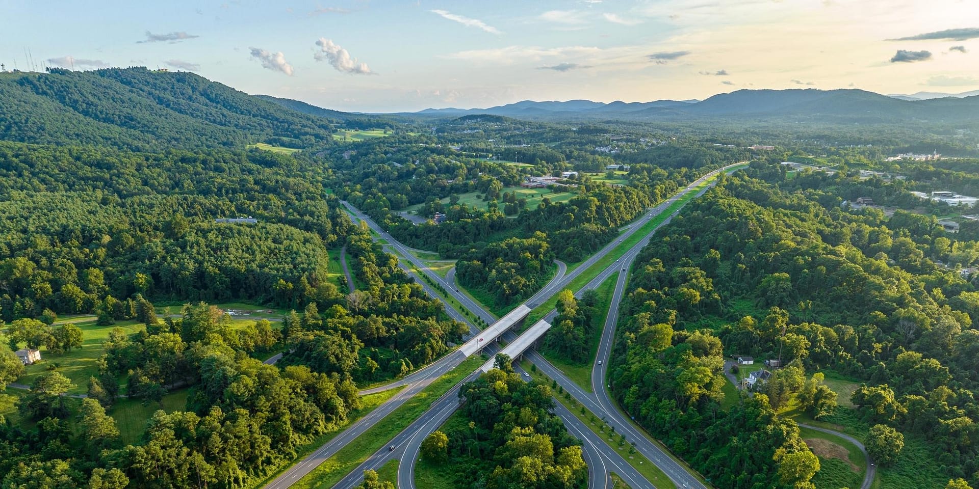 aerial image of a highway interchange, with forest and amounts on all sides
