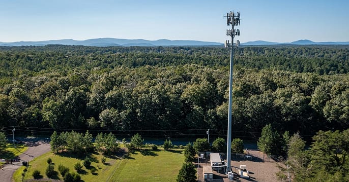 photo of cell tower with forests and mountains in background